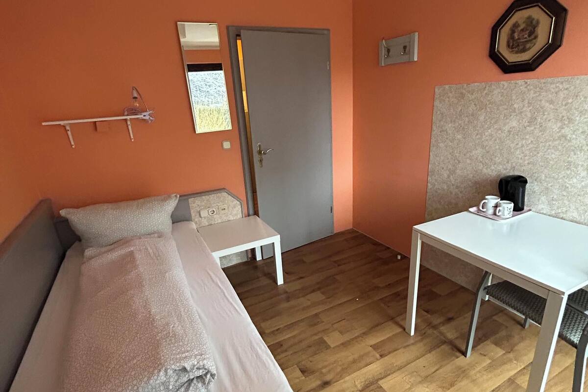 Une pièce comprenant un lit, une petite table, une chaise et un bureau.