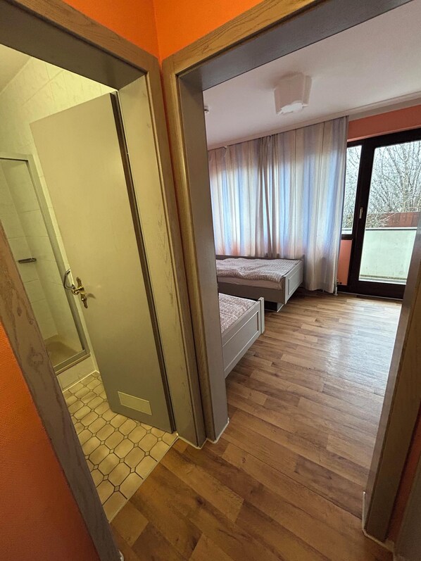 A bedroom with a bed, a window with curtains, and a view of the outdoors. - 2-Rent Group Hostel Rooms AUB162 (Munich)