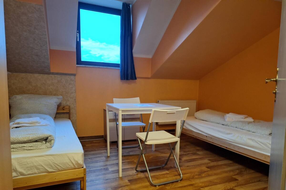 Une petite pièce agréable, avec un lit simple, un bureau et une chaise.