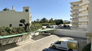 A parking area with a white van labeled "Check-in Portugal" and several cars.