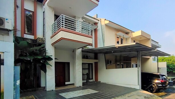 Une maison moderne à deux étages, dotée d’un garage fermé et d’un balcon.