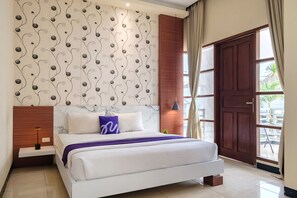 A modern bedroom with a large bed, a nightstand, a wall-mounted lamp, and a view of the outside through a large window. - INNCA Jatidiri Villa, Semarang (Semarang)