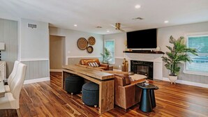 Una sala de estar moderna con una mesa de centro de madera, un sofá de cuero y una chimenea.