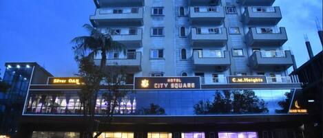 A multi-story hotel with balconies, a sign for 'City Square', and a 'Silver Oak' sign.