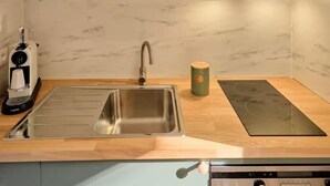 A modern kitchen with a stainless steel sink, a built-in stove, and a coffee maker. - Superb Cosy Studio, Terrace, parking, ski locker close to slopes. (Vars)