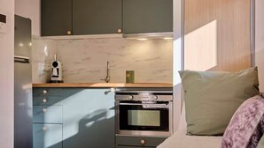 A compact kitchen with dark cabinets, a built-in oven, and a coffee maker. - Superb Cosy Studio, Terrace, parking, ski locker close to slopes. (Vars)