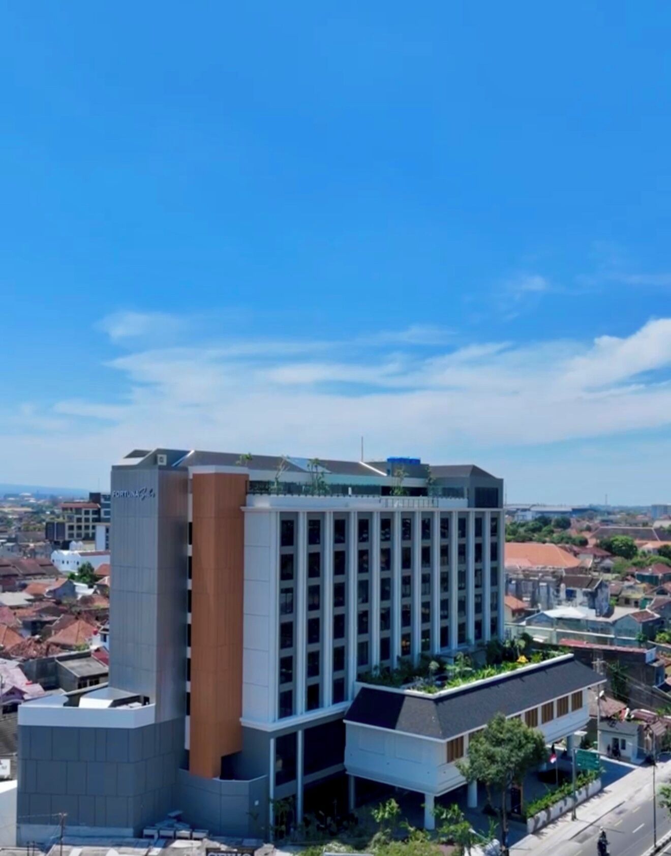 A multi-story hotel with a modern design, featuring a prominent vertical section and a flat roof.