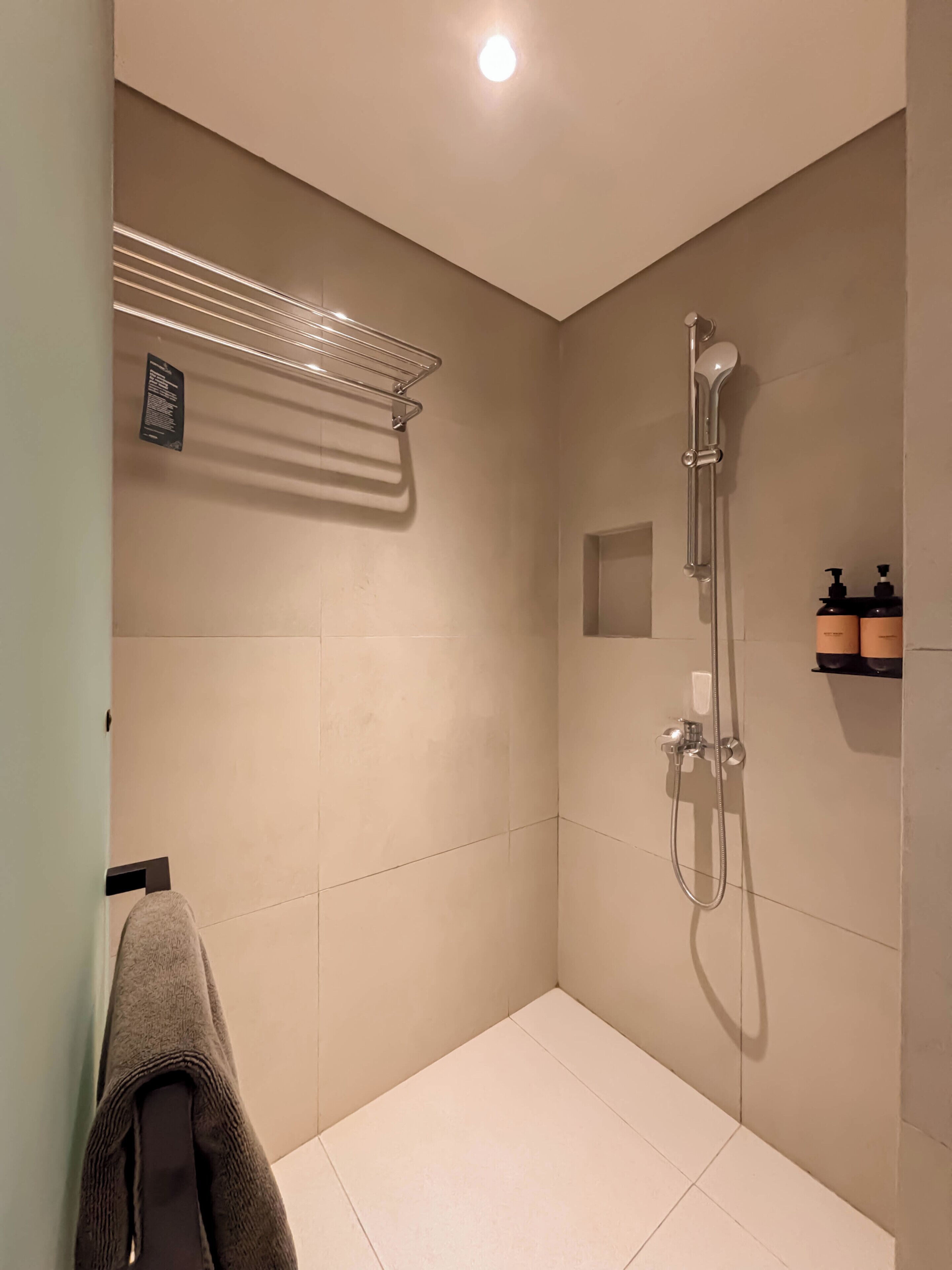 Eine moderne Dusche mit Handbrause und am Wand montiertem Wasserhahn.