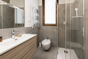 Een douche, handdoeken, toiletpapier