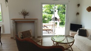 A living room with a fireplace, a glass table, a sofa, and a TV. - Vacation home -6 to 8 people (Cléder)