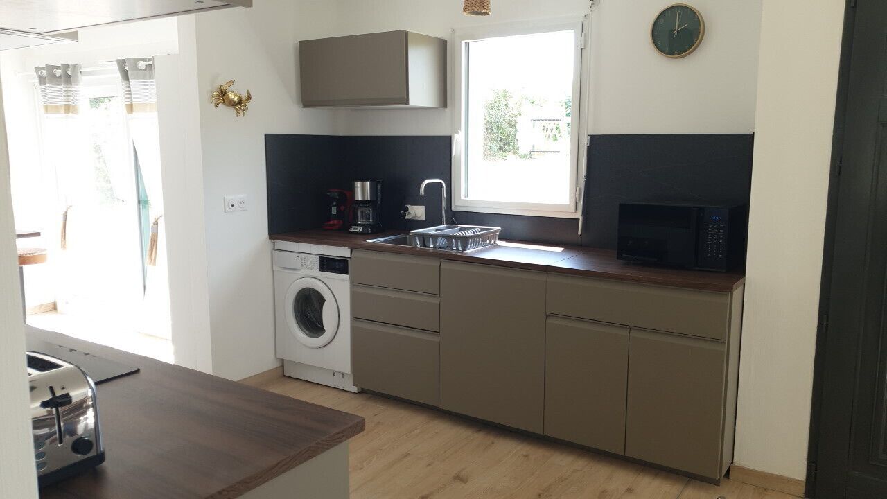 A compact kitchen with a washing machine, a microwave, and a sink.