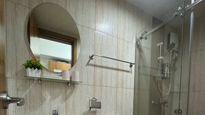 Une salle de bain équipée d’un lavabo, de toilettes et d’une douche à parois de verre.