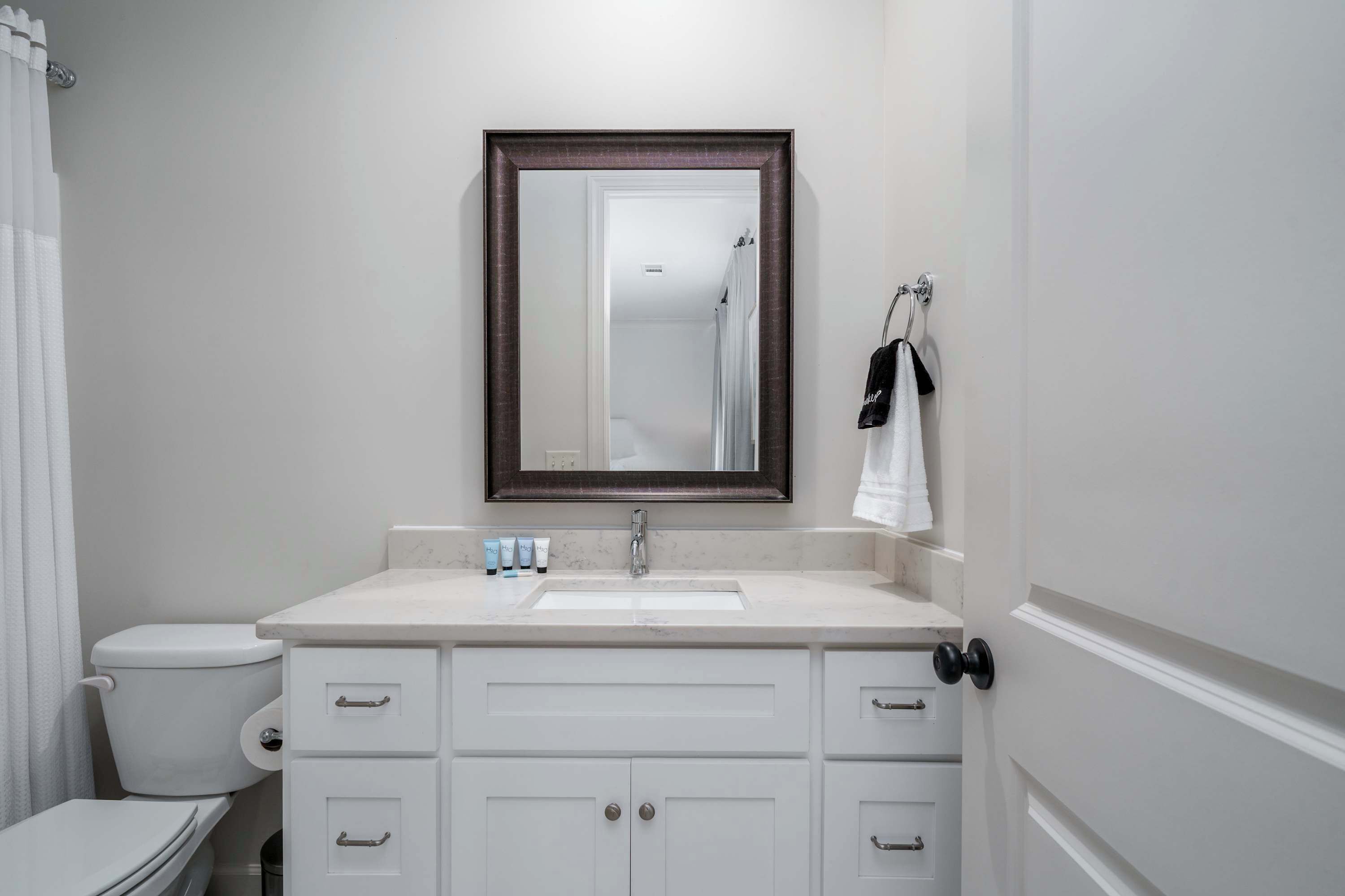 A bathroom with a white sink, a mirror, and a toilet.