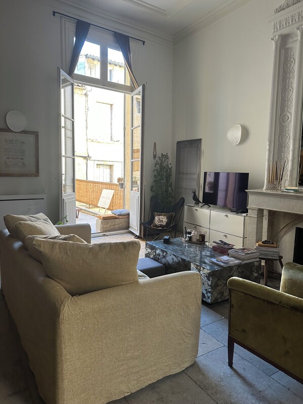 Ein Wohnzimmer mit einer Couch, einem kleinen Tisch, einem Fernseher und einem Kamin.