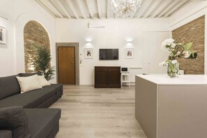 A modern living room with a sofa, a TV, a wooden cabinet, and a decorative plant.