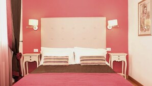 A hotel room with a large bed, two bedside tables, and a headboard with wall-mounted lamps. - Borgo degli Angeli Resort & Spa (Partinico)