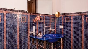 A bathroom with a blue sink, a mirror, and a decorative vase. - Borgo degli Angeli Resort & Spa (Partinico)