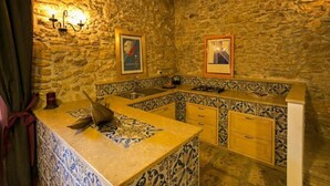 A kitchen with stone walls, a tiled backsplash, and a wooden countertop. - Luxury Suite Wellness & Resort (Partinico)