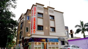 Ein Hotel namens "Hotel Greenway" mit moderner Fassade, zahlreichen Fenstern und einem geparkten Auto davor.
