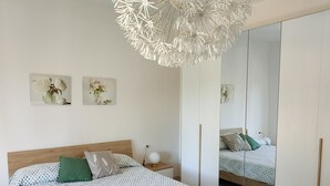 Una camera da letto con un letto, un comodino e un grande specchio.