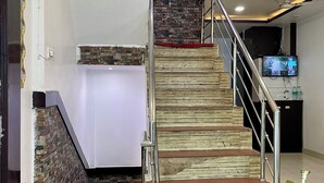 A staircase with a modern design, a flat roof, and a wall-mounted television.