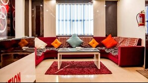 A living room with a red sofa, a glass coffee table, and a red rug.