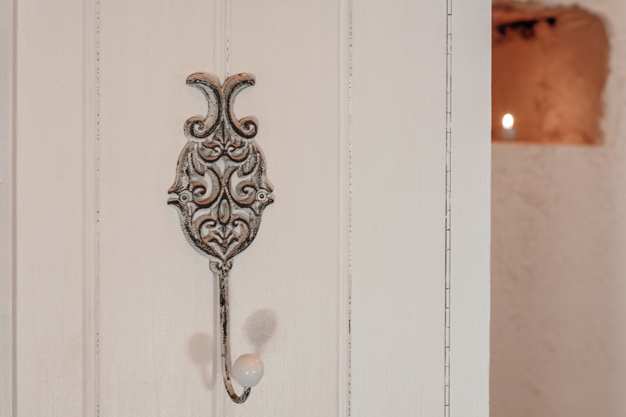 Una maniglia decorativa con un motivo elaborato e un pomello sferico.