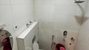 Un baño pequeño con azulejos, inodoro, lavabo y ducha.