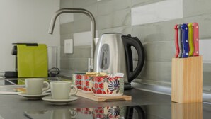 A kitchen counter with a kettle, cups, and a knife block. - Addaura Marina Apartment by Wonderful Italy (Palermo)