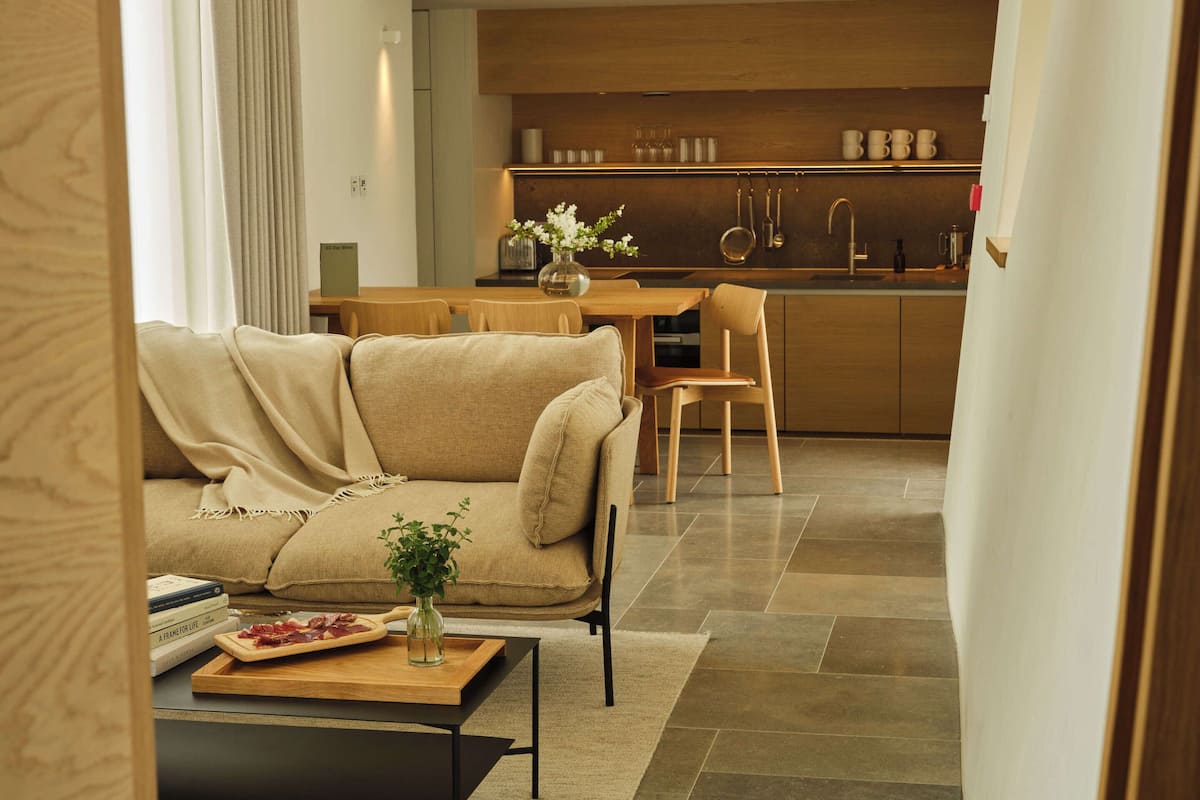 Ein modernes Wohnzimmer mit einer Couch, einem Couchtisch und einem Essbereich mit Stühlen.