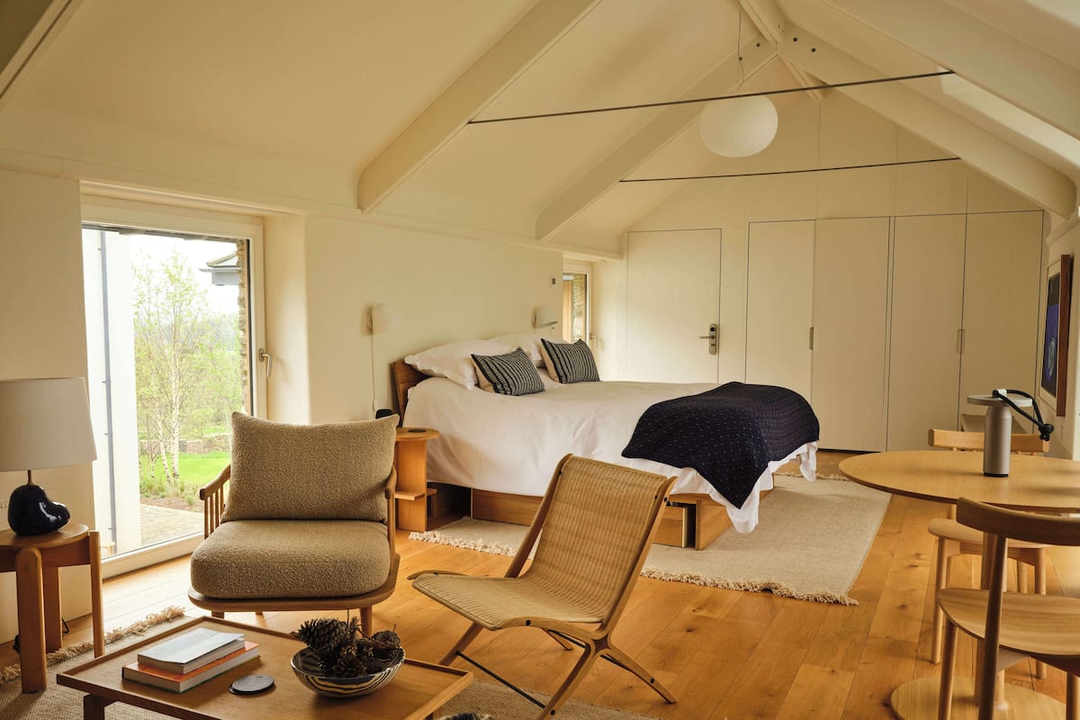 Ein gemütliches Schlafzimmer mit einem großen Bett, einem Holztisch und einem Stuhl.