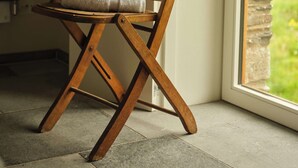 A wooden chair with towels placed on it, positioned near a window with a view of greenery outside. - Fowlescombe Farm (Ivybridge)