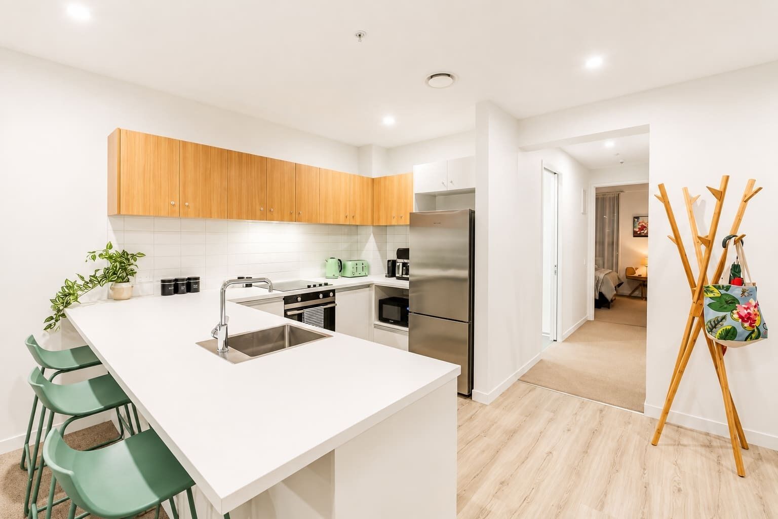 A modern kitchen with a central island, stainless steel appliances, and wooden cabinets.