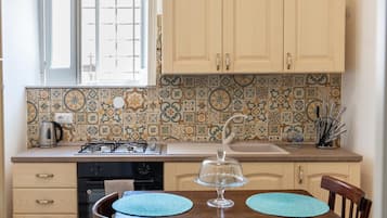 Horno, placa de cocina, cafetera o tetera y trona infantil
