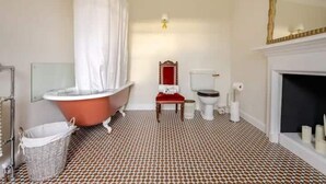 A bathroom with a bathtub, toilet, and a mirror. - The Squirrel Room Energetic & Inspiring (Kinross)