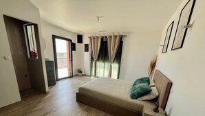 A spacious bedroom with a large bed, a wooden floor, a sliding door to a balcony, and a view of the outdoors. - Villa panoramic view (Narbonne)