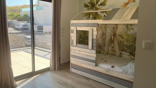 A room with a large window, a sliding door, and a bunk bed with a mural of an elephant and a parrot. - Villa panoramic view (Narbonne)