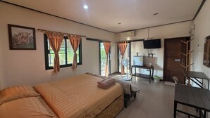 A bedroom with a bed, a desk, a chair, a TV, and a window with curtains. - Hug Wang Homestay (Wang Saphung)