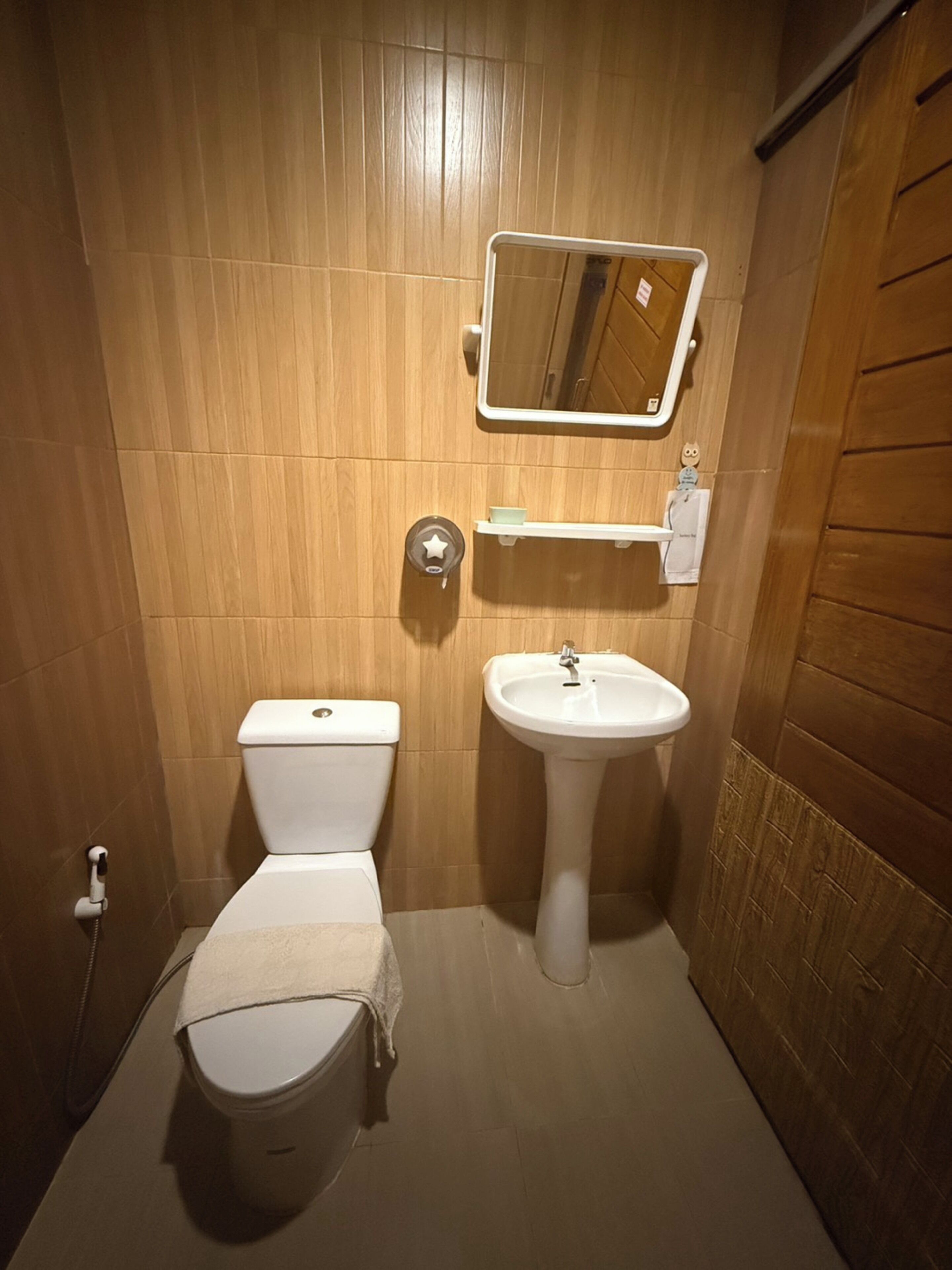 Ein kleines Badezimmer mit Toilette, Waschbecken und Spiegel.