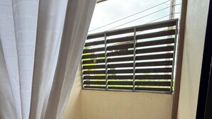 A small balcony with a wooden floor, a metal railing, and a view of the sky and power lines. - Hug Wang Homestay (Wang Saphung)
