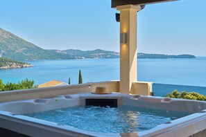 Un jacuzzi con vistas a una amplia extensión de agua y tierra distante.