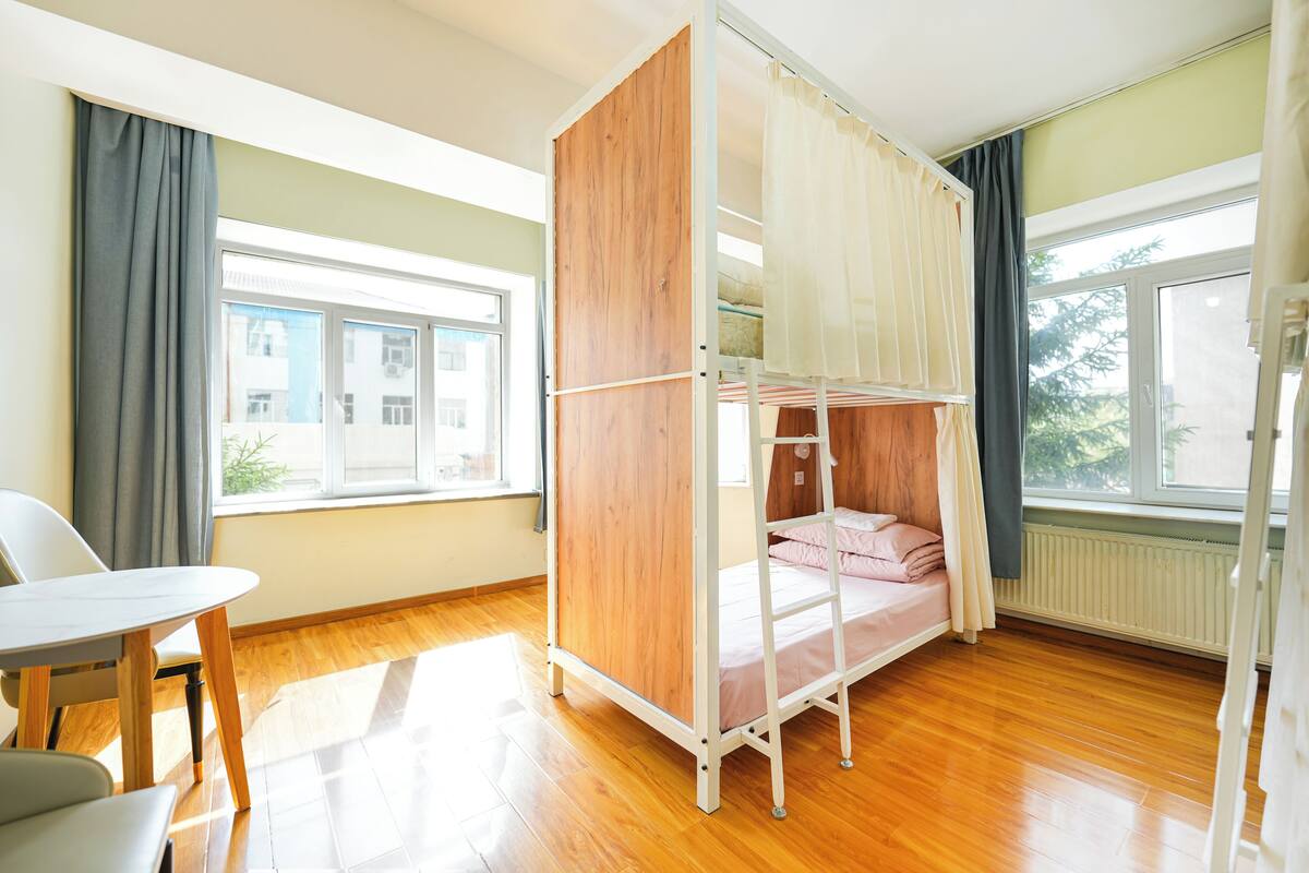 A room with a bunk bed, a table, and a chair.
