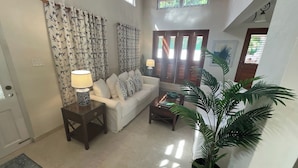 A living room with a sofa, a coffee table, a lamp, and a potted plant. - Jack's Place - by ZenBreak (Mullins)
