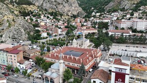 Une ville dotée d’une architecture historique, avec notamment un bâtiment remarquable surmonté d’une tour et d’un dôme, entouré de quartiers résidentiels et bordée par un paysage montagneux.