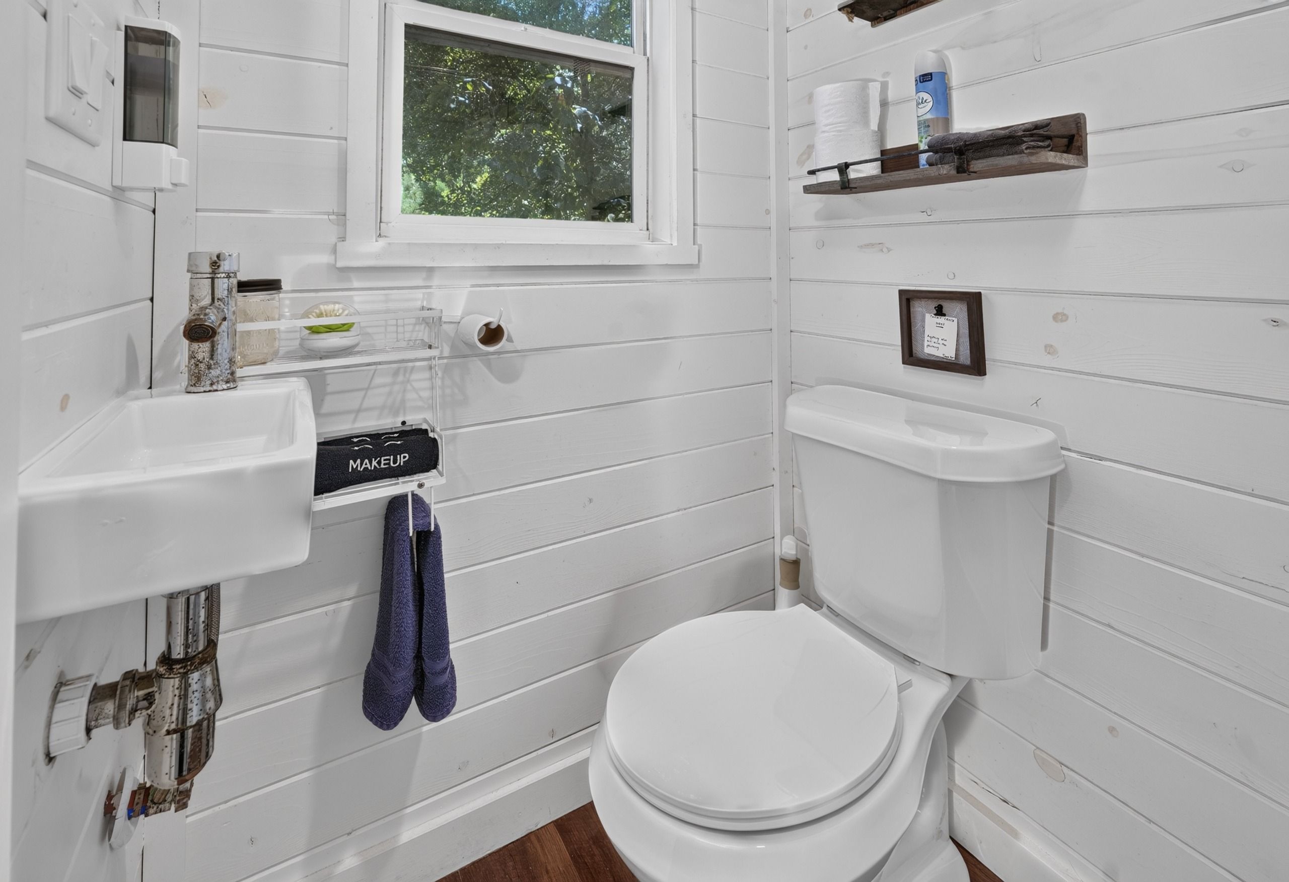 Ein Badezimmer mit Toilette, Waschbecken und Fenster.