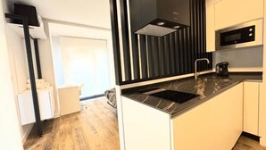 Een moderne keuken met een zwart-wit kleurenschema, een ingebouwde magnetron en een zwarte koffiezetapparaat.