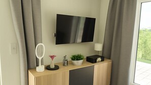 Um banheiro moderno com toucador, espelho e televisão de tela plana fixada acima.