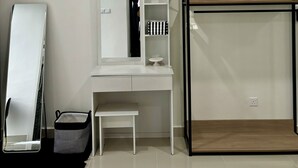 Ein modernes Schlafzimmer mit weißem Schreibtisch, einem Spiegel, einem Etagenbett und einer Klimaanlage.