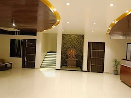 Un vestíbulo moderno con escalera, mostrador de recepción y una pared decorativa.