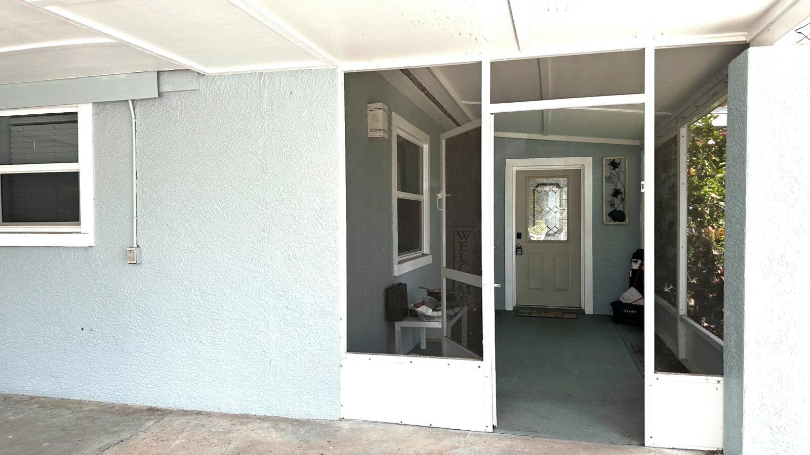A residential building with a light blue exterior, a front door, and a visible interior space with a window and a door.